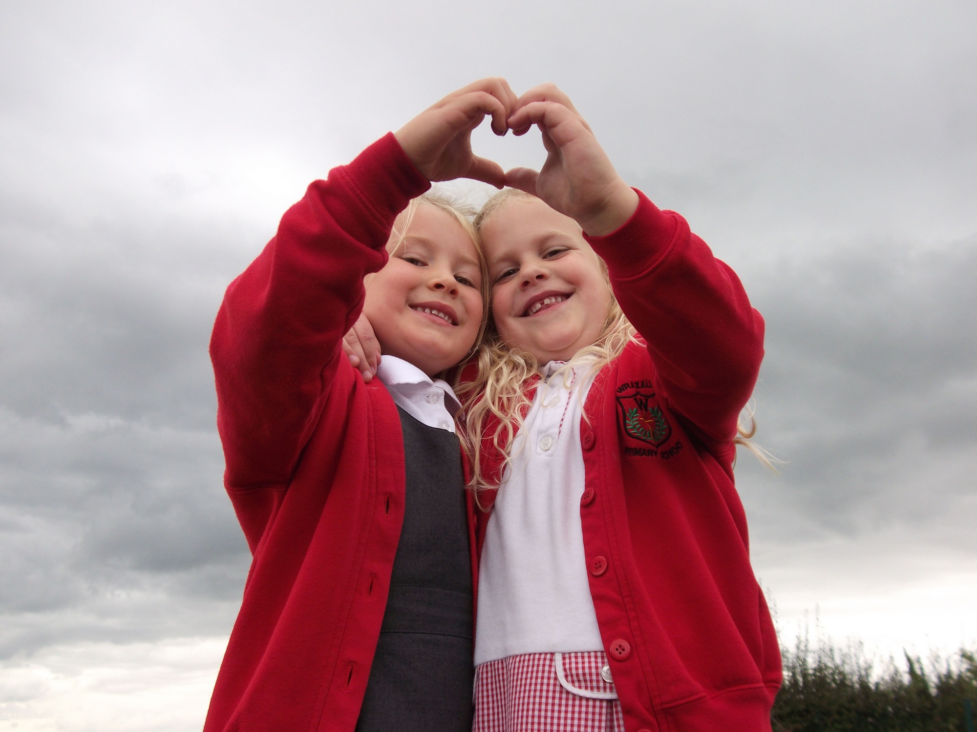 Image of two girls making a heart with their hands